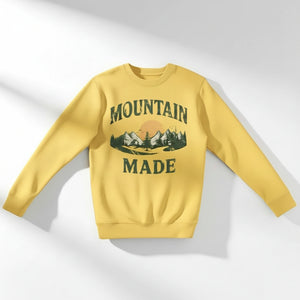 Yellow sweatshirt with 'Mountain Made' graphic on a white background